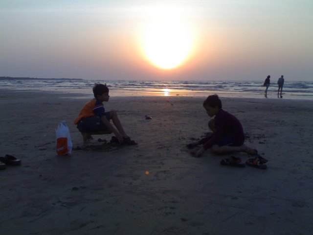 Sunset in the sands of Aksa-Bombay..Sagar,Sahil making houses on the sand, Mamta and her father walking by the sea in the horizons